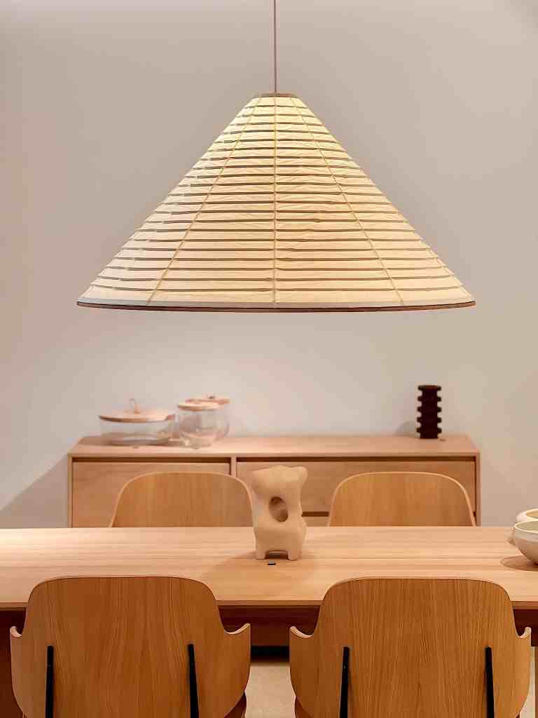 Architekt wnętrz - projekt dedykowany aranżacji jadalni Aranżacja jadalni z drewnianym stołem i designerską lampą
